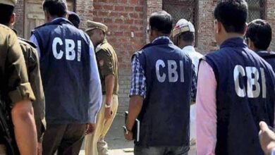 The image of a CBI officers, wearing jackets marked "CBI", are seen entering a premises accompanied by local police personnel during an official investigation.