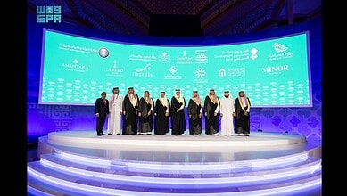 Officials and delegates stand on stage during the TOURISE 2025 Summit in Riyadh, where the Tourism Development Fund announced new projects.