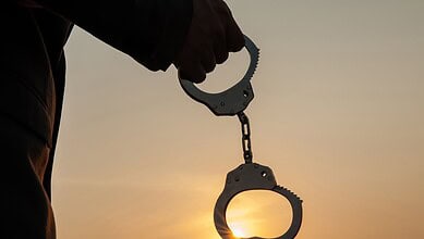 A person holding a handcuff.