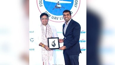 Image shows Minister Sridhar Babu accepting a memento infront of a white background