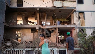 Residents look at a damaged apartment complex that neighbours say was hit during US strikes to capture Venezuelan President Nicolás Maduro in Catia La Mar of Venezuela on Sunday. (AP/PTI)