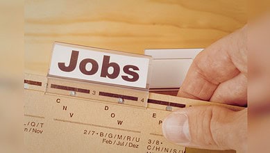Hand holding a wooden ruler with "Jobs" sign, symbolising US employment data.