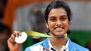 PV Sindhu holding her Olympic silver medal, smiling after winning at Rio 2016.