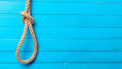 Rope hanging against a bright blue wooden wall, symbolising a distressing scene.