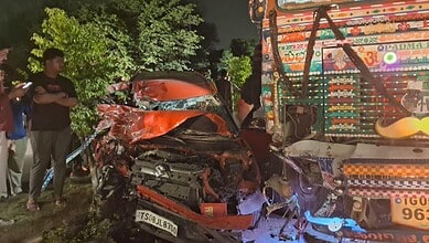 Onlookers watch the truck and car after the accident in Mechal