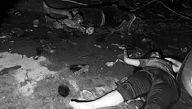Nighttime accident scene with a person lying on the ground amidst debris and rocks.