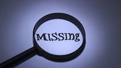 Magnifying glass highlighting the word 'MISSING' on a dark background.