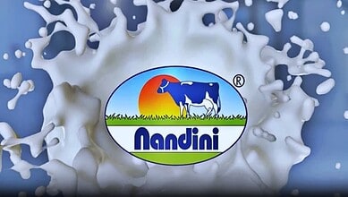 Nandini Dairy Milk logo splashing into milk, symbolising freshness and quality.