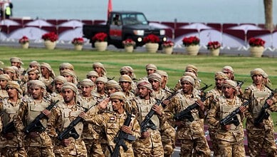 Soldiers in uniform participating in a military parade, standing in formation with rifles, during a forma.
