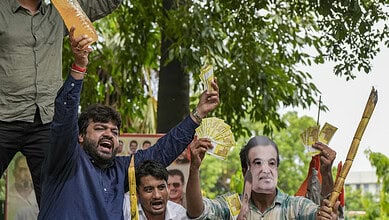Protesters holding Indian currency notes and bamboo sticks during IYC protest against 'ganne ka juice'.