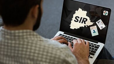 Person using laptop with SIR map and ID cards, highlighting online form issues.