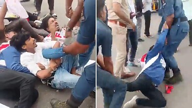 Clash between police and protesters on the street, with people on the ground and officers involved.