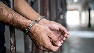 Close-up of hands in handcuffs, symbolising arrest or detention.