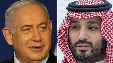 Two men, one in a suit and the other in traditional Middle Eastern attire, engaged in conversation.