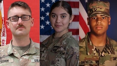 Three US military personnel in uniform with American flags in the background.