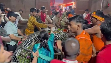 Crowd gathered around a fallen metal structure during a temple stampede in Bihar.