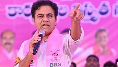 KTR speaking passionately at a public event with a pink backdrop and supporters.