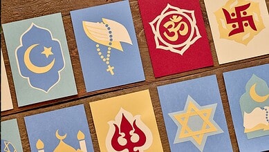 Collection of various religious symbols on colourful cards, representing different faiths.