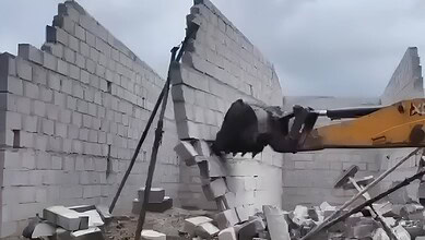 Demolition of illegal structures in Cyberabad by CMC using heavy machinery.