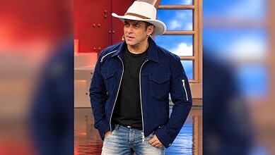 Salman Khan in a blue jacket and white hat on the Bigg Boss set.