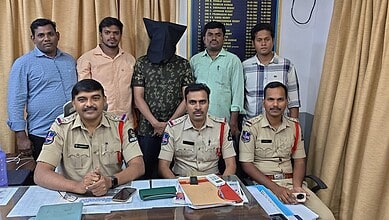 Police officers and a person with a black hood in a room with a board and curtains.