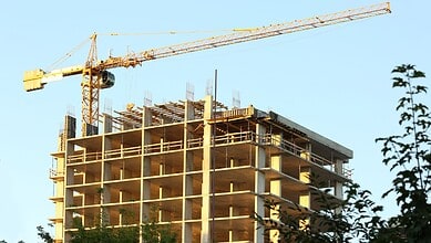 Construction site with a high-rise building under development and a tower crane in Hyderabad.