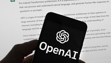 OpenAI logo displayed on a smartphone screen with a document in the background.