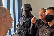 Israeli officials and a soldier visit a Palestinian prisoner in a detention centre.