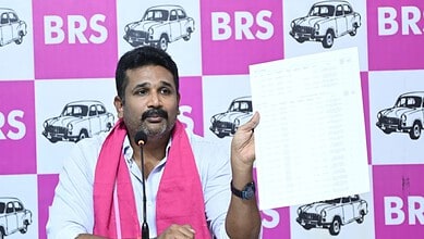 Revanth Reddy holding a document during a press conference at BRS event.