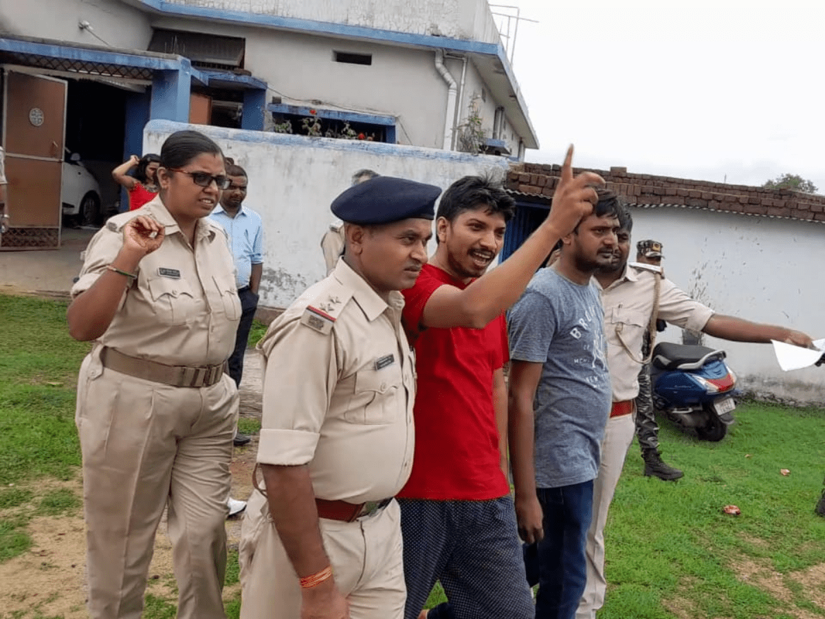 Independent Jharkhand journalist Rupesh Kumar Singh (in red shirt) being escorted by the police after his house was raided in 2022