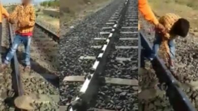 boy placing stones on railway track