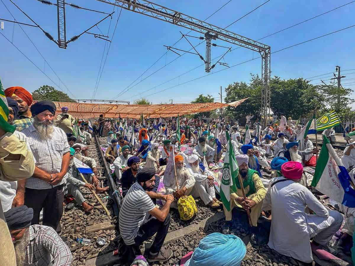 Farmers sit on railway tracks during a protest at the Shambhu border, in Patiala district,