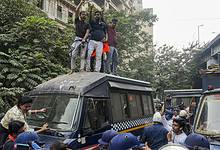 Members of West Bengal Hindu Jagran stand on top of a police van as police personnel detain other agitators during a protest against the killing of a Hindu youth in Bangladesh near the Bangladesh Deputy High Commission in Kolkata on Tuesday. (PTI Photo/Manvender Vashist Lav)