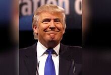 Republican leader Donald Trump with a confident smile at a political rally.