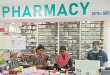 Pharmacy interior with staff assisting customers in a well-stocked drugstore.