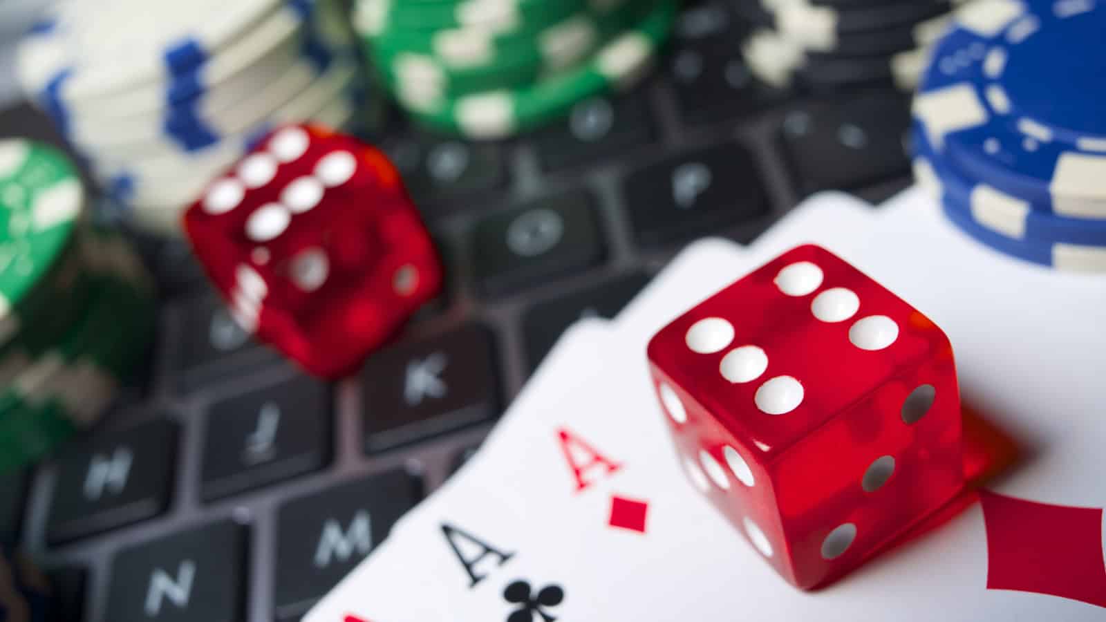 Online gaming fraud and gambling chips on a laptop keyboard in Hyderabad.