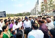 Group of officials and locals discussing the new government college project in Kondapur.