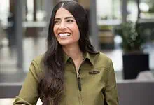 Asha Sharma, Indian-origin CEO of Microsoft Gaming, smiling in a modern office setting.