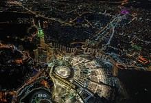 Aerial view of a vibrant city at night showcasing bright lights and urban development.