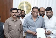 Officials review documents related to the delayed compensation process.