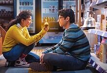 Young woman and man sitting on the floor in a store, sharing a moment of connection.