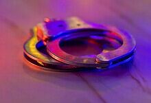 Handcuffs on a wooden surface, representing legal action against public nuisance offences.