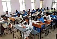 Students taking Telangana SSC exams with OMR sheets in a classroom setting.