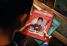 Child holding 'Pocket Potters' book from Blooming India’s new series at a bookstore.