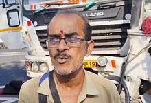 Man speaking at the scene of a road accident involving a sand tipper and RTC bus in Telangana.