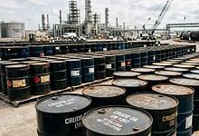 Oil barrels stacked at a refinery or storage facility.