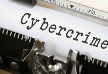 Close-up of the word "cybercrime" on a typewriter with a pen, highlighting cyber fraud issues.