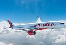 Air India aircraft flying above clouds, highlighting staff travel misuse investigation.