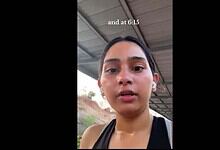 Woman recording video outdoors under shelter, close-up shot.