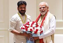 Telangana Chief Minister with Prime Minister Modi exchanging a flower bouquet during a meeting.